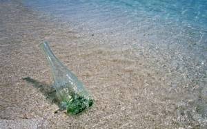 Бутылка в песке у воды